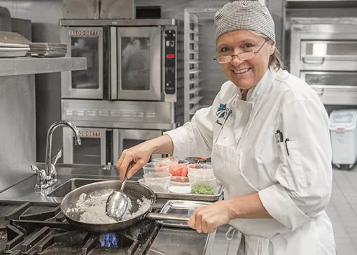 student learning how to prepare food