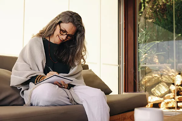 healthcare professional writing in a journal