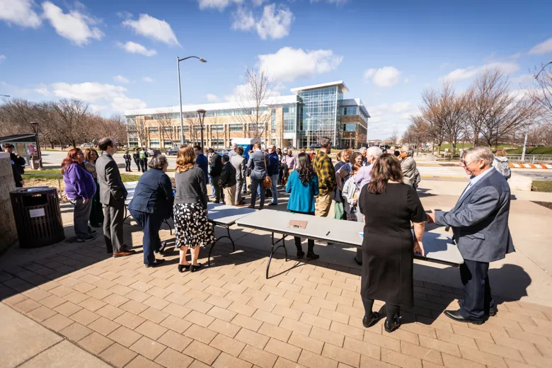 A large group of people outside looking away from camera.
