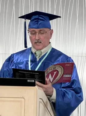 ReEntry Program graduate in cap and gown speaking at a podium