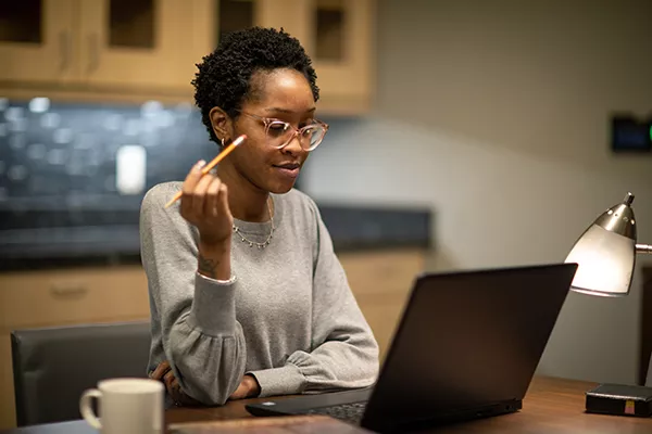 a person with a pencil and laptop computer